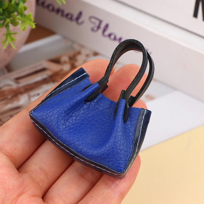Handcrafted miniature blue handbag with realistic texture, perfect for dollhouse enthusiasts and collectors.