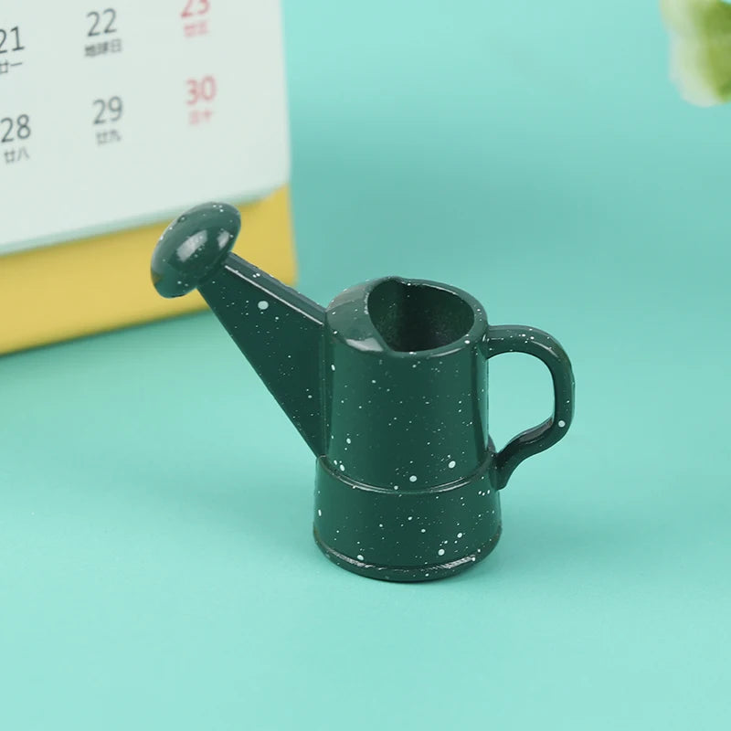 Miniature dark green watering can, perfect for small garden setups and dollhouse displays. Ideal for indoor plant care.