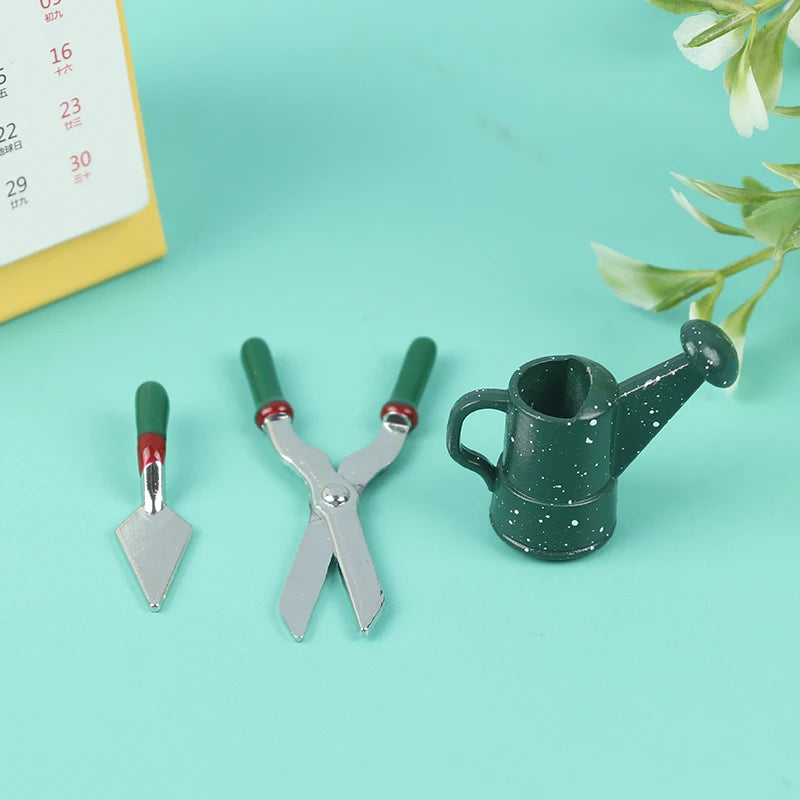 Miniature gardening tool set with a spade, shears, and a watering can on a turquoise background, perfect for dollhouse enthusiasts.