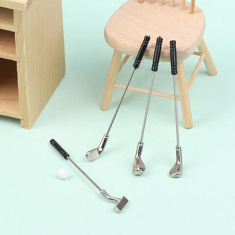 Miniature golf club set for dollhouses with four clubs and a tiny ball, perfect for dollhouse enthusiasts and collectors.