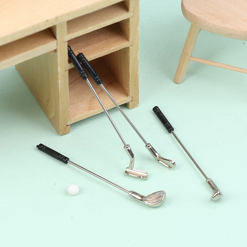 Miniature golf club set with five detailed clubs and tiny ball, perfect for dollhouse sports enthusiasts.