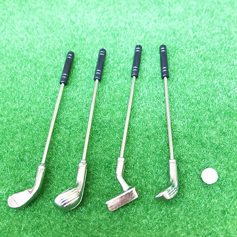Miniature golf club set with four silver clubs and a ball on green turf, perfect for enhancing dollhouse play.