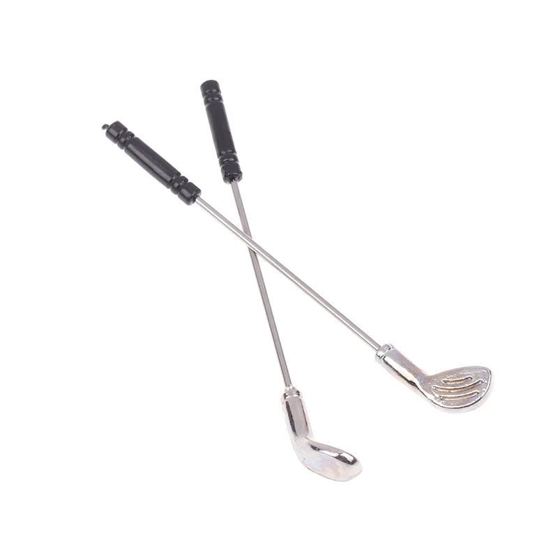 Miniature golf club set with two chrome-plated clubs, perfect for enhancing dollhouse sports scenes.