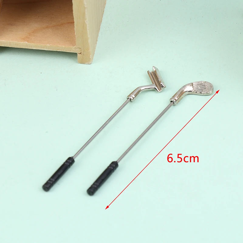 Miniature golf club set with two detailed clubs for dollhouse decor, measuring 6.5cm, perfect for tiny golfing scenes.