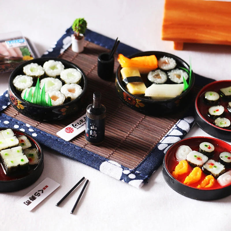 Miniature Japanese sushi set with realistic rolls, sashimi, and soy sauce on a bamboo mat, perfect for dollhouse decor.