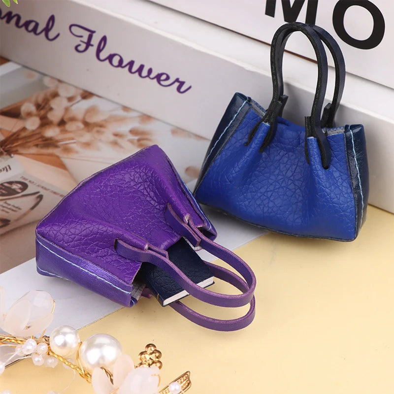 Purple and blue miniature dollhouse handbags with realistic texture, perfect for collectors and dollhouse enthusiasts.