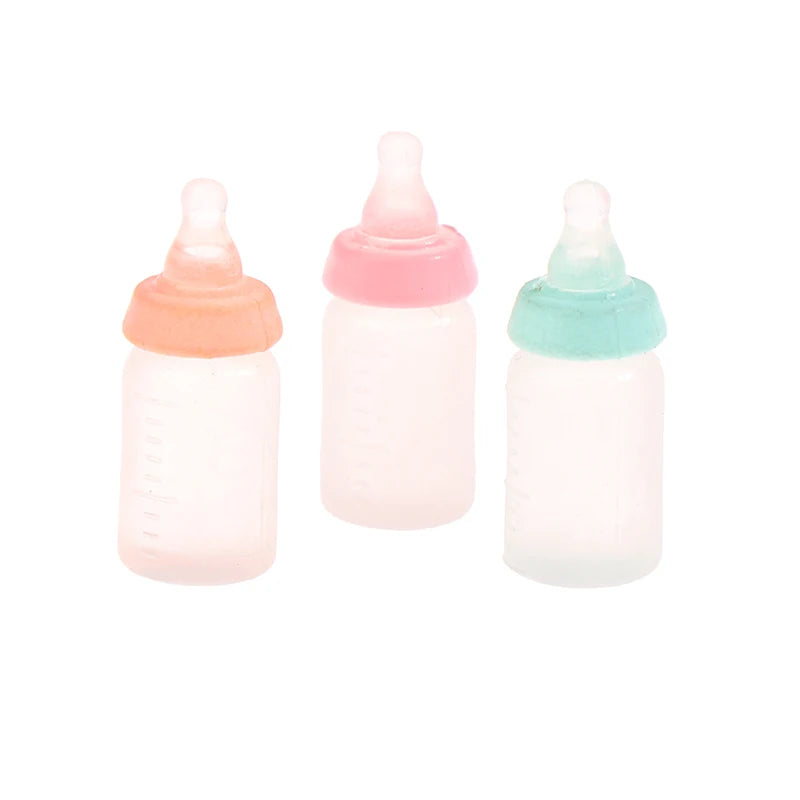Three colorful miniature baby bottles for dollhouses, featuring pink, orange, and teal caps, perfect for realistic play.