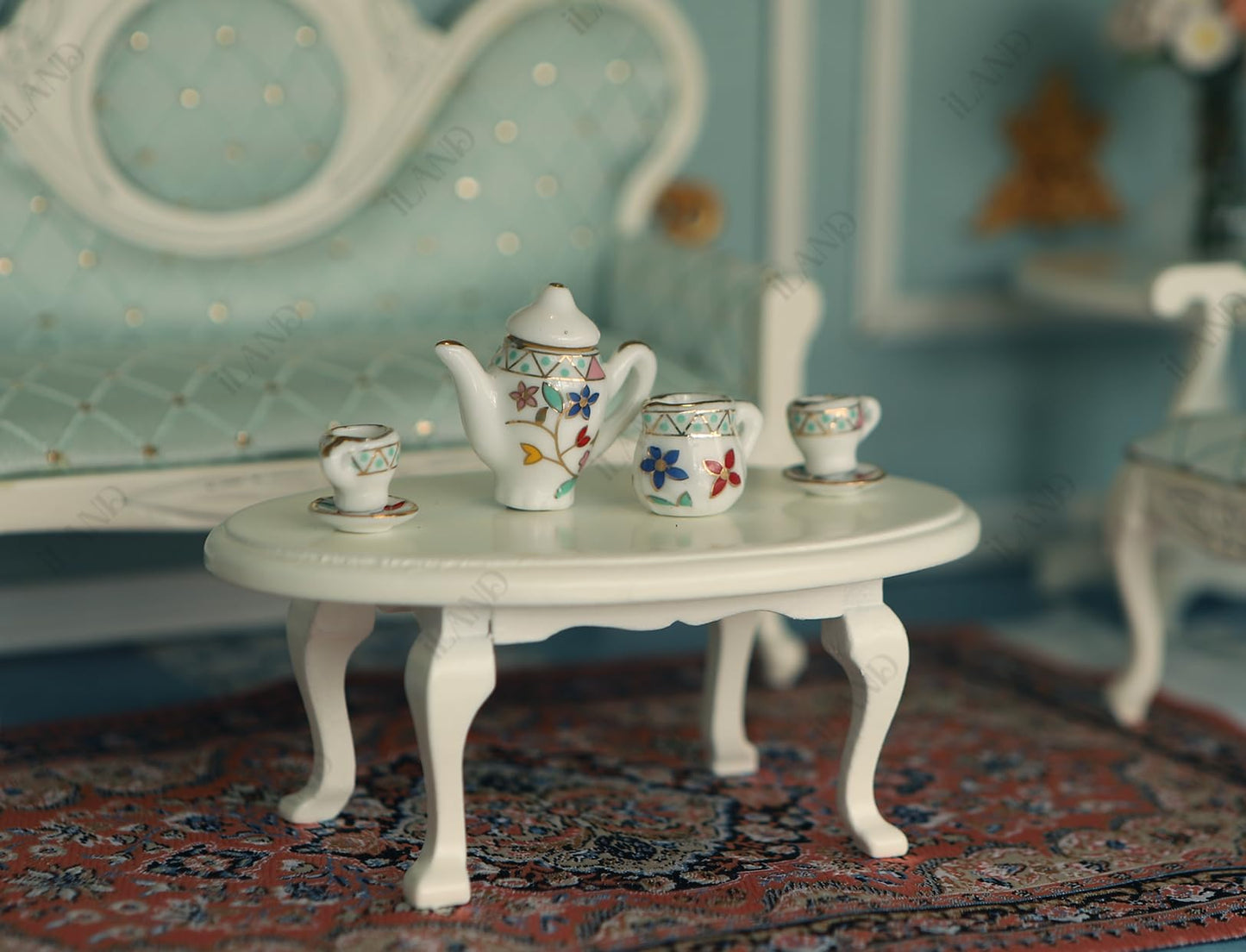 Victorian dollhouse tea set on white table, featuring floral teapot and cups, perfect for miniature décor and gifts.