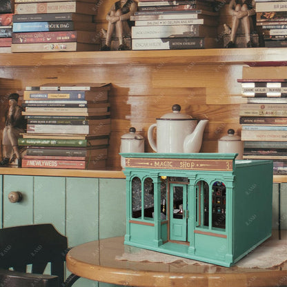 Miniature coffee shop dollhouse in teal, set against a warm, cozy backdrop of books and vintage decor.