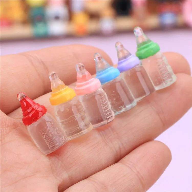 Colorful miniature baby bottle set for dollhouses, perfect for realistic play. Ideal accessory for dollhouse collectors.