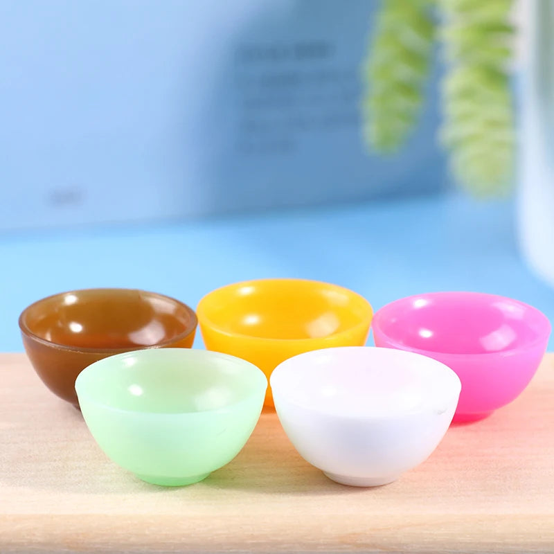 Colorful miniature dollhouse bowls on wooden surface, featuring vibrant pastel shades for detailed play settings.