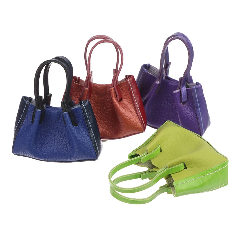 Colorful miniature dollhouse handbags in vibrant blue, red, purple, and green, perfect for dollhouse decor.