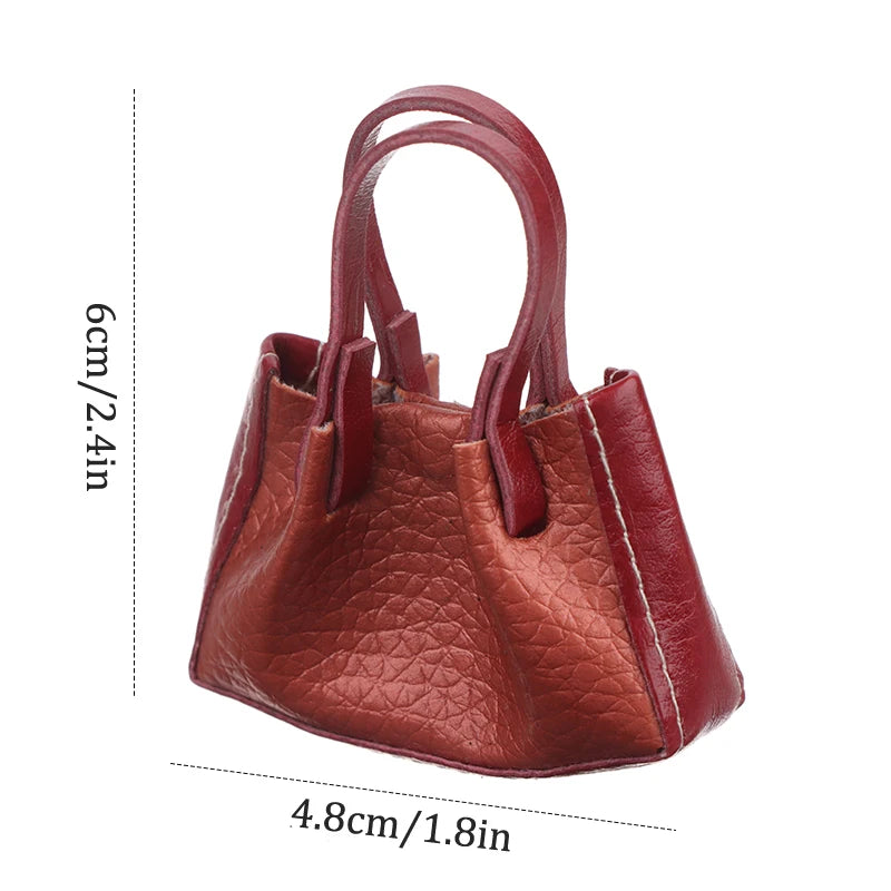 Miniature dollhouse handbag in rich burgundy leather with realistic texture, perfect for collectors and enthusiasts.