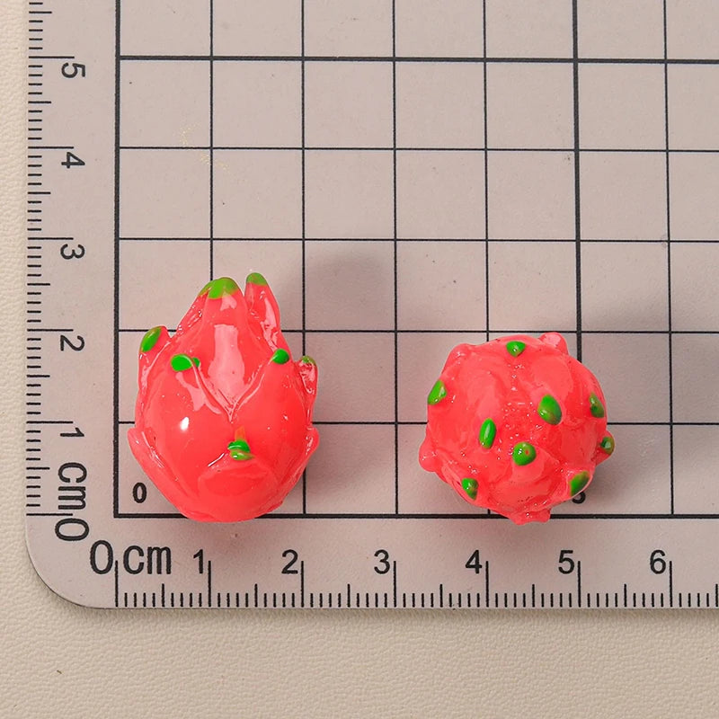 Miniature resin fruit for 1:12 dollhouse, depicting vibrant pink dragon fruit with green accents, shown with a ruler for scale.