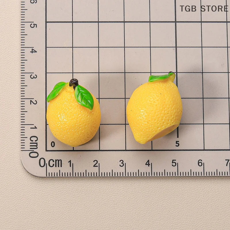 Miniature resin lemons for 1:12 dollhouse display, featuring vibrant yellow color and detailed leaf accents on a grid background.
