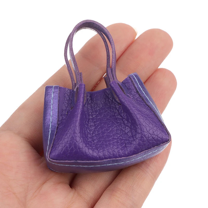 Vibrant purple miniature dollhouse handbag with textured design, showcased in a hand for scale. Perfect for collectors.